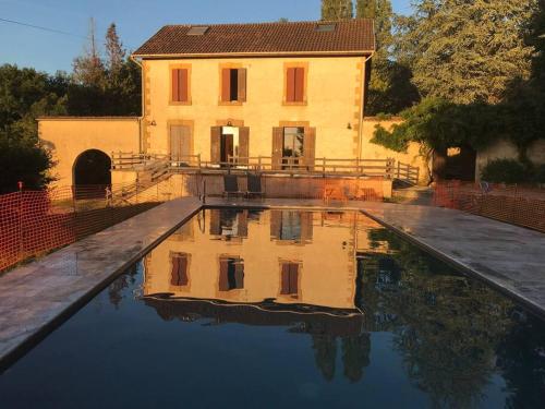 un reflet d'un bâtiment dans un bassin d'eau dans l'établissement Dordogne, Le Cambou, 5 ch avec piscine et terrain 3 ha, à Vergt-de-Biron