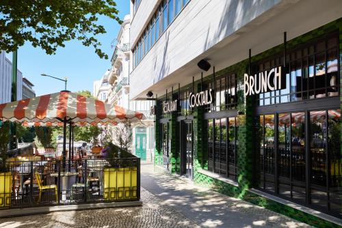 a store with tables and umbrellas on a street at Mama Shelter Lisboa in Lisbon
