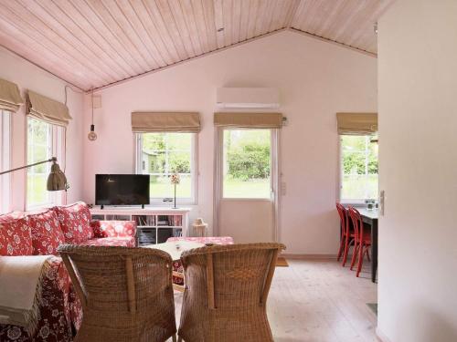 a living room with a couch and a table with chairs at 6 person holiday home in Dronningm lle in Gilleleje