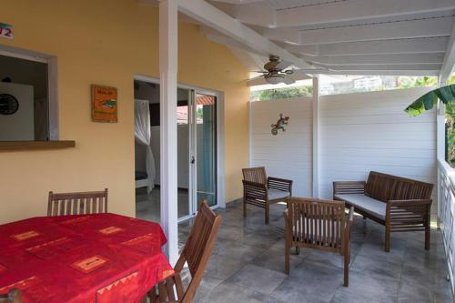 a patio with a table and chairs on a porch at Eden plage in Les Trois-Îlets