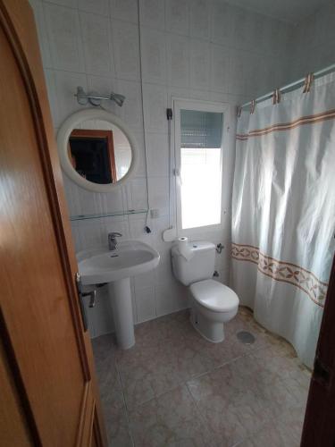 a bathroom with a toilet and a sink and a mirror at Casa Carmen in Bargas