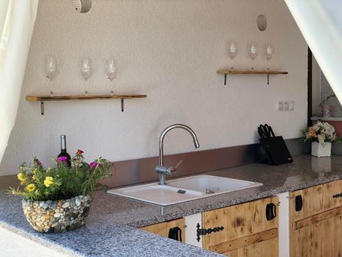a kitchen counter with a sink and flowers on it at Villa Emili in Posušje