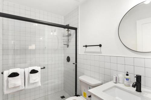 Un baño blanco con lavabo y espejo. en The Aloha, en Chandler