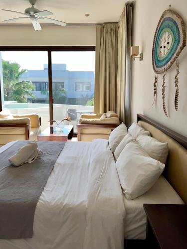 a bedroom with a bed with pillows and a large window at Amazing Luxury Penthouse with sunset,sunrise view, private Jacuzzi and rooftop pool in Tulum