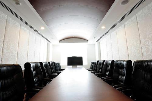 a conference room with a long table and leather chairs at Gurmon Hotels Sohna Road Gurugram, a member of Radisson Individuals in Sohna
