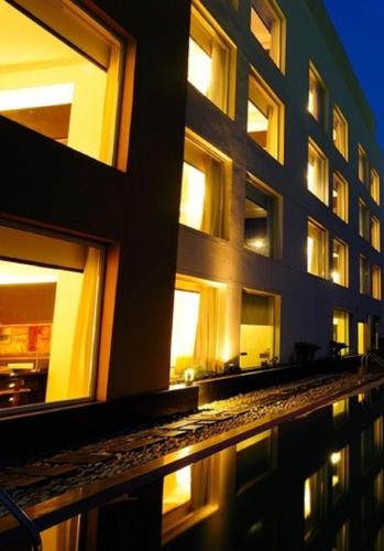 a building with windows and a reflection in the water at Gurmon Hotels Sohna Road Gurugram, a member of Radisson Individuals in Sohna