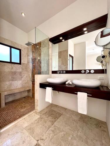 a bathroom with two sinks and a large mirror at Amazing Luxury Penthouse with sunset,sunrise view, private Jacuzzi and rooftop pool in Tulum