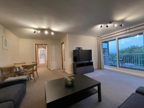 a living room with a couch and a table at Spacious 2-Bedroom Flat Near Surbiton Station in Surbiton