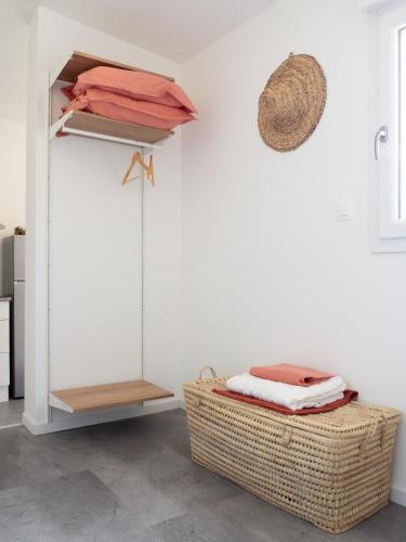une chambre avec une étagère en osier et un panier dans l'établissement L'HACIENDA CHAMPENOISE, à Châlons-en-Champagne