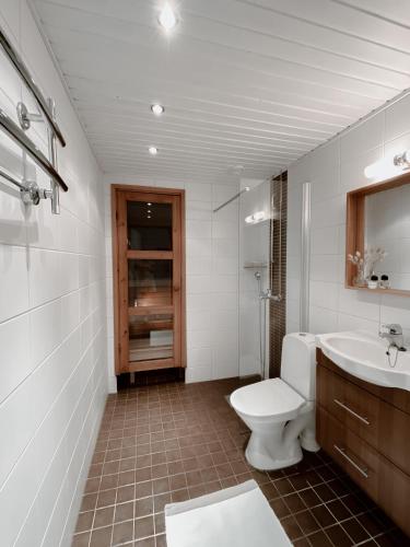 a white bathroom with a toilet and a sink at Modern one bedroom Apartment with Sauna near Airport in Vantaa
