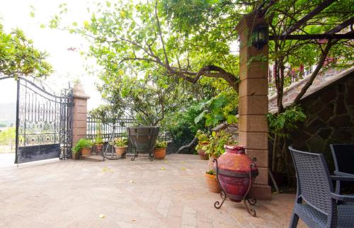 a patio with a large vase and chairs and a gate at Ιρις in Mithymna