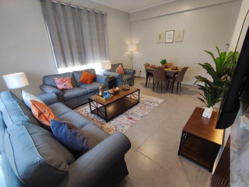 العبير شقة فندقية في King Abdullah Economic City: غرفة معيشة مع أريكة زرقاء وطاولة