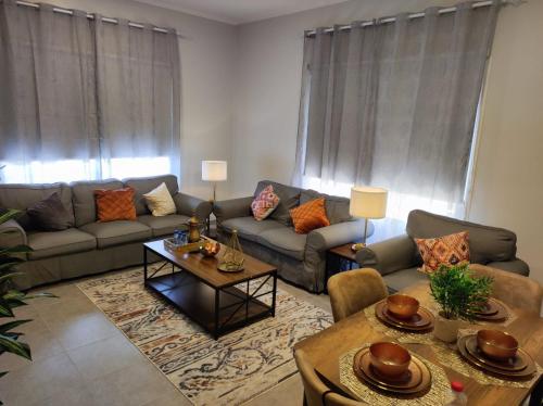 العبير شقة فندقية في King Abdullah Economic City: غرفة معيشة مع أريكة وطاولة