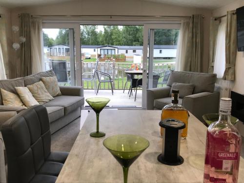 a living room with a table with a bottle of wine at St Andrew's view in Tydd Saint Giles