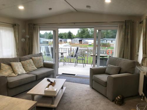 a living room with two couches and a table at St Andrew's view in Tydd Saint Giles