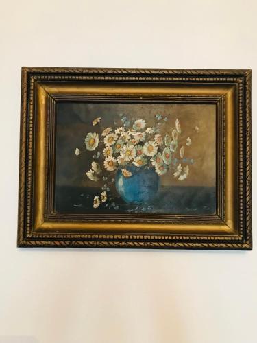 a painting of flowers in a blue vase at Joseph Hayn Apartments in Sighişoara