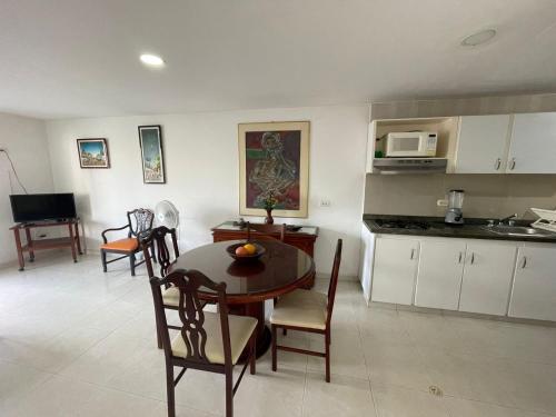 a kitchen with a table, chairs and a refrigerator at Apartamentos En Edificio Portofino in Cartagena de Indias