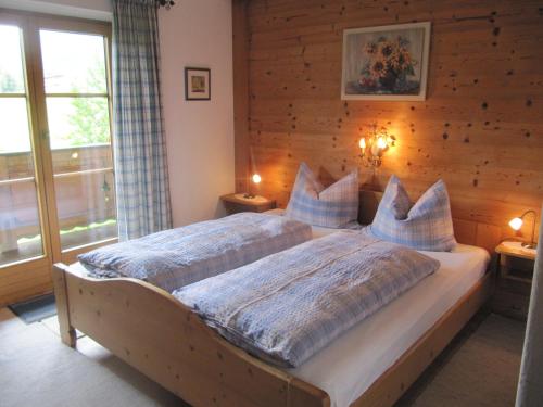 a bedroom with a large bed with blue pillows at Haus Friedl in Kitzbühel