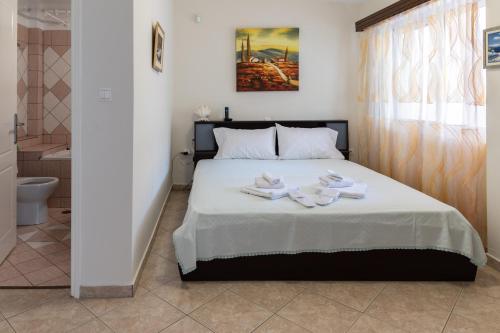 1 dormitorio con 1 cama con toallas en Blue Horizon View, en Lávrion