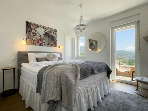 a bedroom with a bed and a large window at Apartments King and Queen in Povile