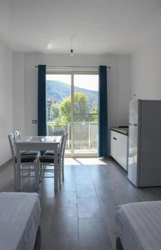 a dining room with a table and a large window at LUMNIK - Shengjin- Hotel & Apartments in Shëngjin