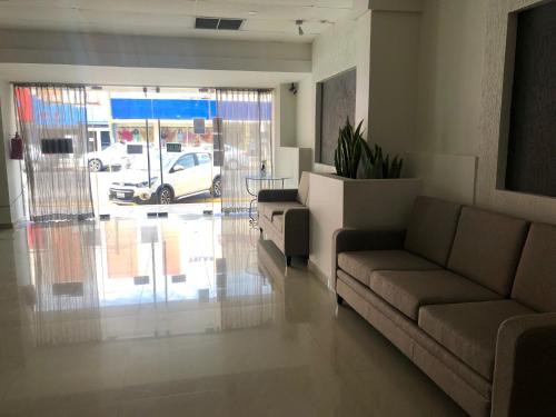 sala de estar con sofá y vistas al aparcamiento en Hotel Lorena en Los Mochis