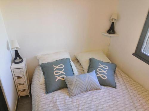 - un petit lit avec 2 oreillers dans l'établissement Porticcio très joli T2 climatisé & grande terrasse à 1km de la plage, à Porticcio