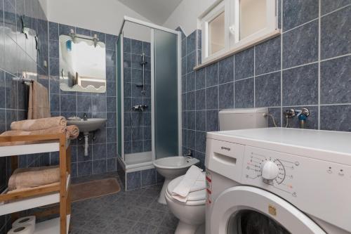 y baño con aseo, lavabo y lavadora. en Panorama Apartment, en Bol