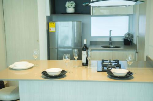 a kitchen with a counter with glasses and a bottle of wine at Suite de lujo Distrito 90 in Barranquilla
