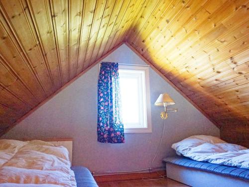 a attic room with two beds and a window at Holiday home in Vreta in Borensberg