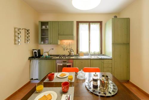 a kitchen with green cabinets and a wooden table at La Casa di Claudia in Gubbio