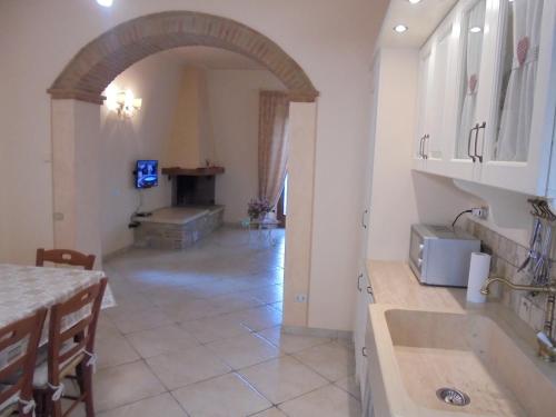 - une cuisine avec une voûte et une table dans une chambre dans l'établissement LA CASA DI CHIANNI La Pieve 2, à Chianni