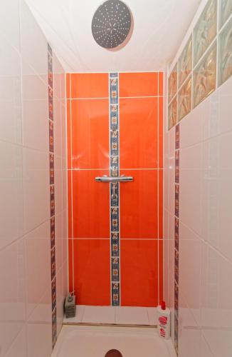 La salle de bains est pourvue d'une douche avec une porte rouge. dans l'établissement Ti Kaz Papang, à Peille