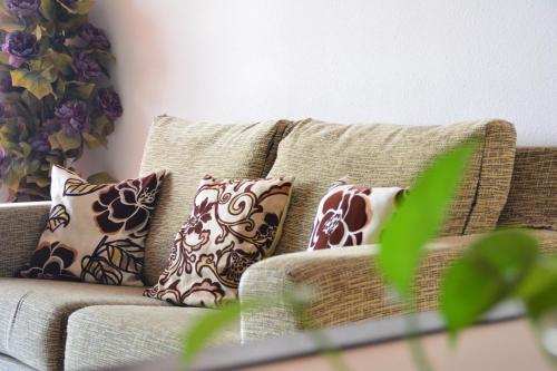 eine Couch mit Kissen darauf in einem Wohnzimmer in der Unterkunft Apartamentos Be Suites Mar de Azahar in Oropesa del Mar