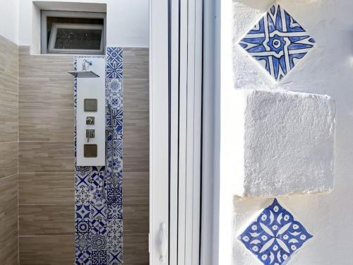 a bathroom with blue and white tiles on the door at Casa Comada - Torre Lapillo in Torre Lapillo