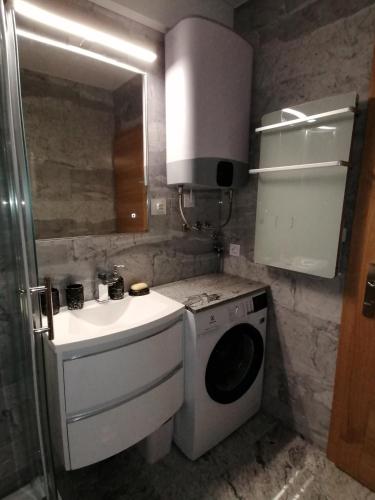 a bathroom with a sink and a washing machine at DOM LORON in Poreč