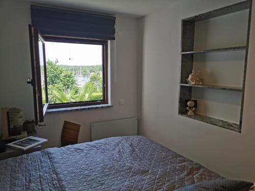 a bedroom with a bed and a window at DOM LORON in Poreč
