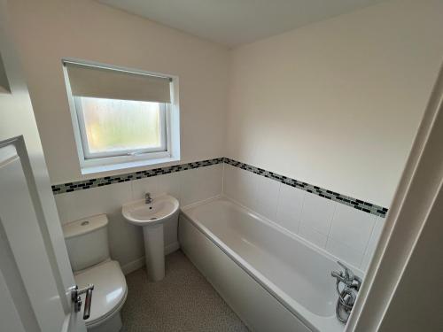 a bathroom with a tub and a toilet and a sink at SUPER 4 Bedroom 9 Person 3 Bathroom MEGA HOUSE in Hull