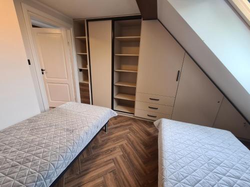sypialnia na poddaszu z 2 łóżkami i szafą w obiekcie Apartament nad BRDĄ , agroturystyka. w mieście Raciąż