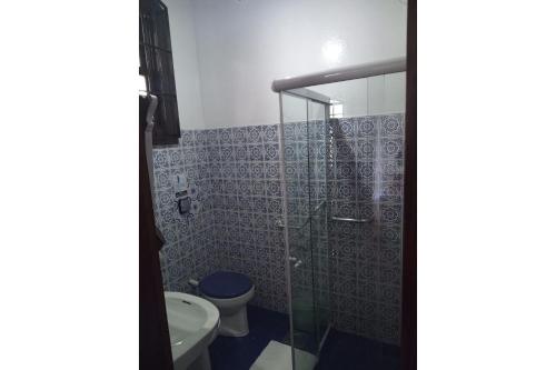 La salle de bains est pourvue de toilettes et d'une douche en verre. dans l'établissement Casa Temporada com Tranquilidade e Aconchego - Petrópolis - RJ, à Petrópolis