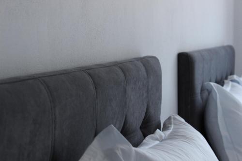 a gray couch with a pillow in a bedroom at LUMNIK - Shengjin- Hotel & Apartments in Shëngjin