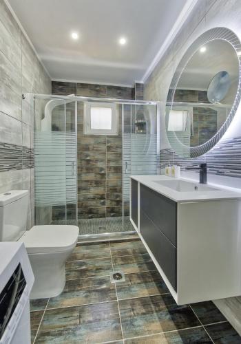 a bathroom with a sink and a toilet and a mirror at Vrachos holiday home in Alikanas