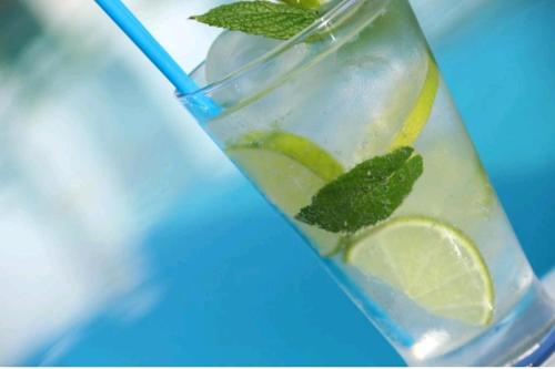 a glass of lemonade with a lime and a straw at Art riad mazighen in El Jadida