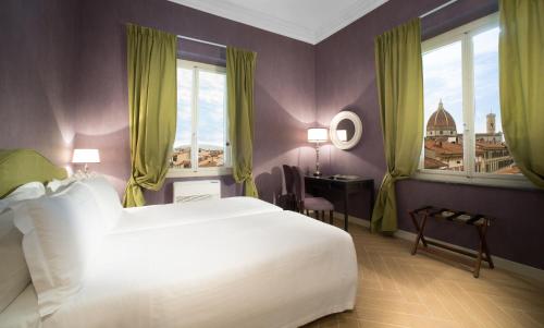 1 dormitorio con 1 cama blanca grande y ventanas en San Giuliano Inn, en Florencia