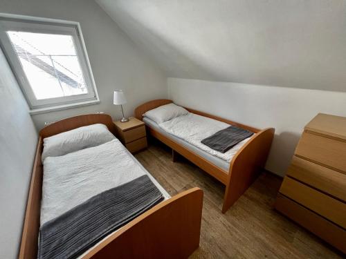 a small room with two beds and a window at Chalupa Kadov in Sněžné