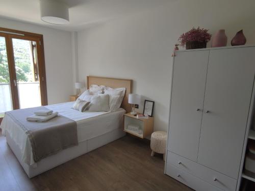 貝納斯克的住宿－Flor de Lis，一间白色卧室,配有一张床和一个梳妆台