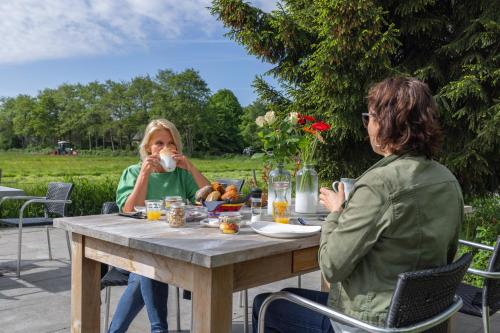 twee vrouwen aan een tafel koffie drinken bij Villa de Hazelaar in Schoorl