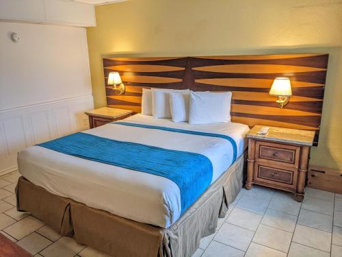 a bedroom with a large bed with a wooden headboard at Quebec Motel in Wildwood