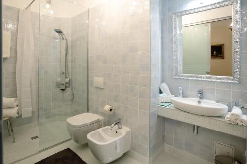 een badkamer met een wastafel, een toilet en een spiegel bij B&B Fotić in Zagreb
