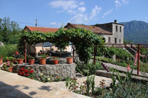a garden with a pergola with plants and flowers at Holiday Home Gazevic in Virpazar